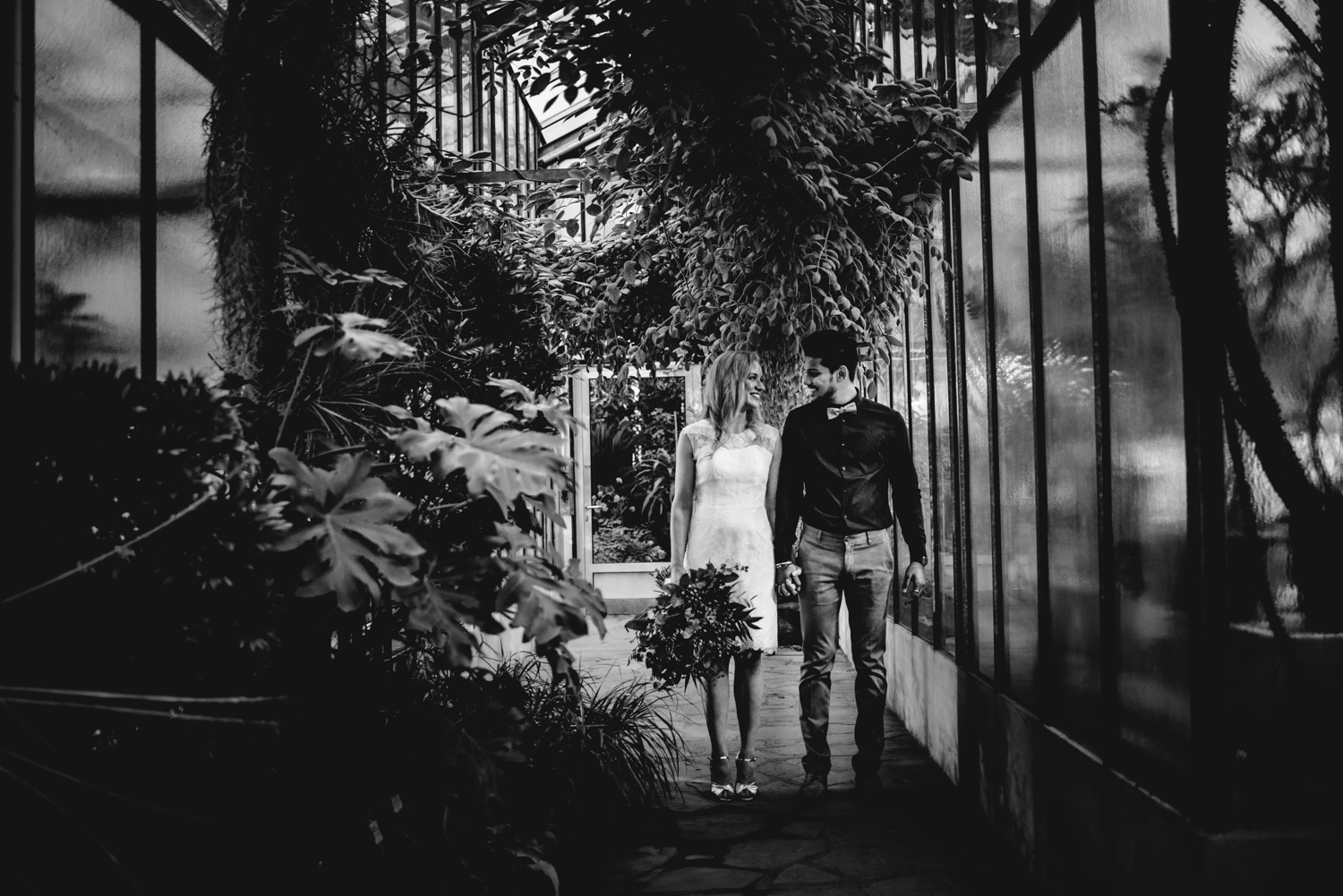 Ein Brautpaar bei einem Elopement-Shooting in Bonn ist umgeben von Pflanzen.