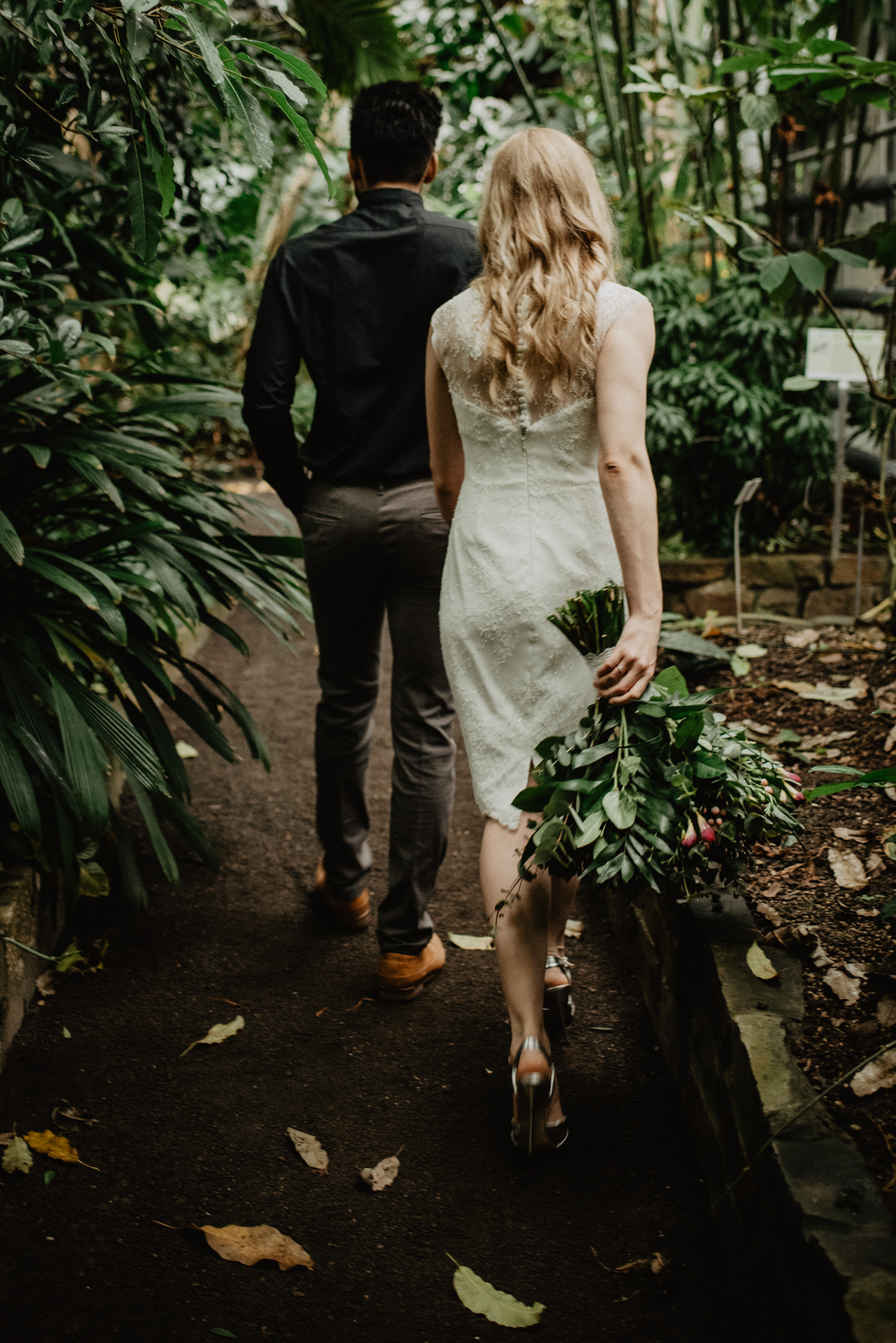 Ein Bräutigam führt seine Braut durch ein tropisches Gewächshaus in Bonn.