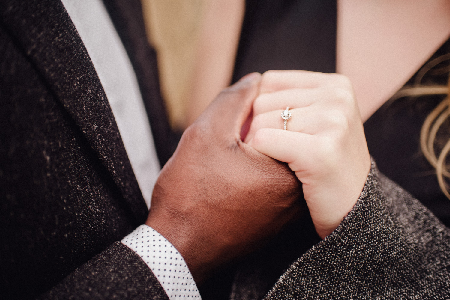 Ein Mann hält die Hand seiner Verlobten, die einen Verlobungsring trägt.