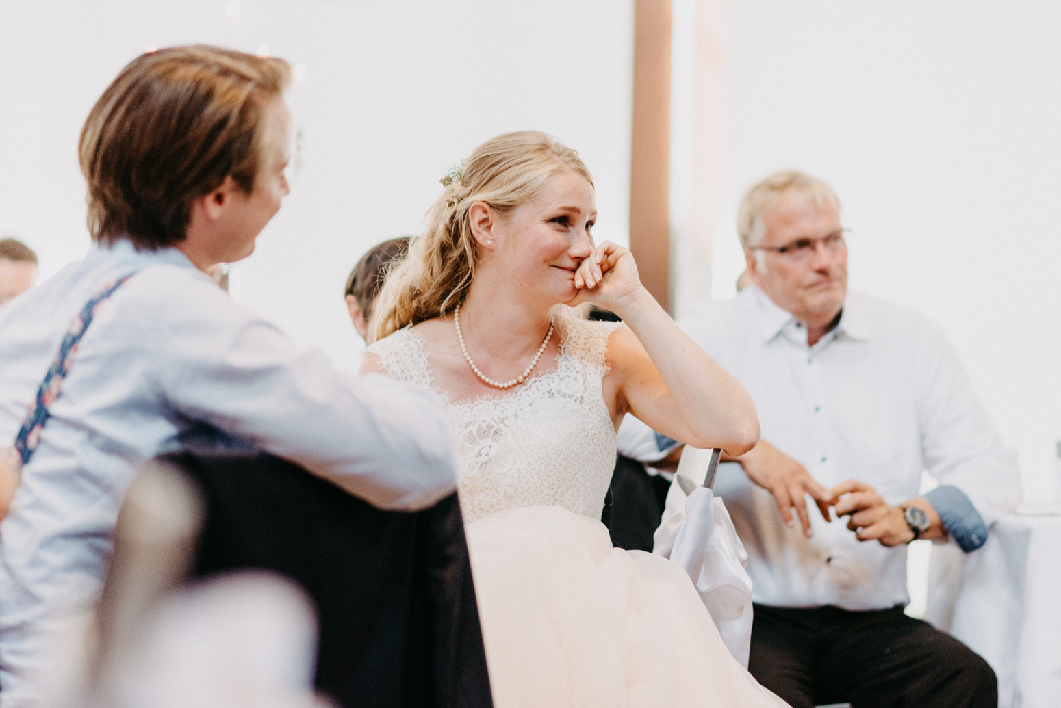 Die Braut weint vor Rührung während einer Rede. Hochzeitsfotografin in NRW Daria Becker von Genuine Bonds